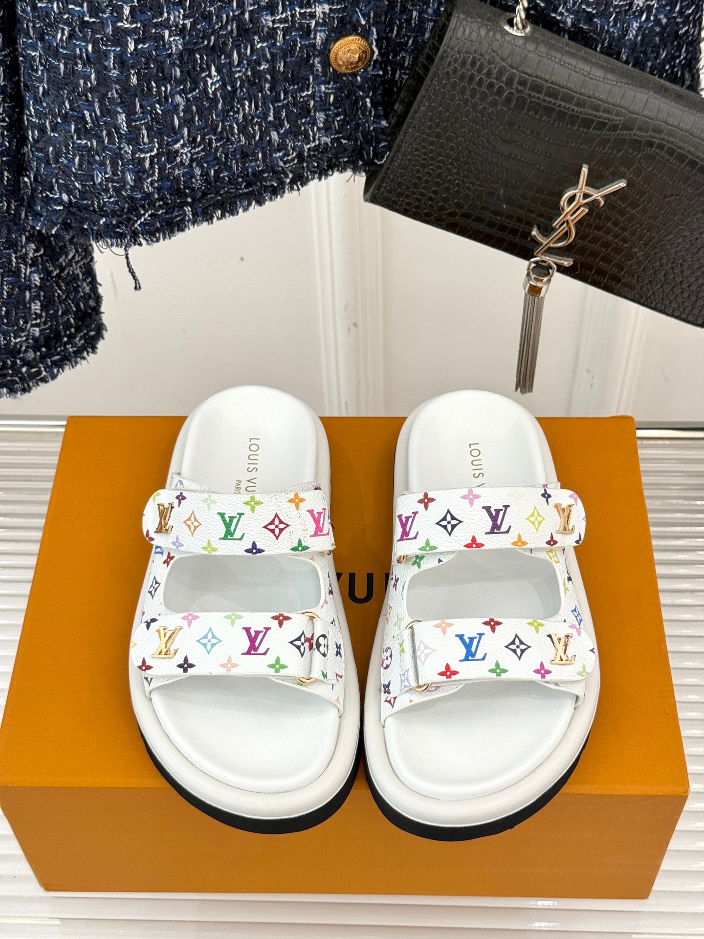White slide sandals with multicolor monogram straps and gold-tone logo detail