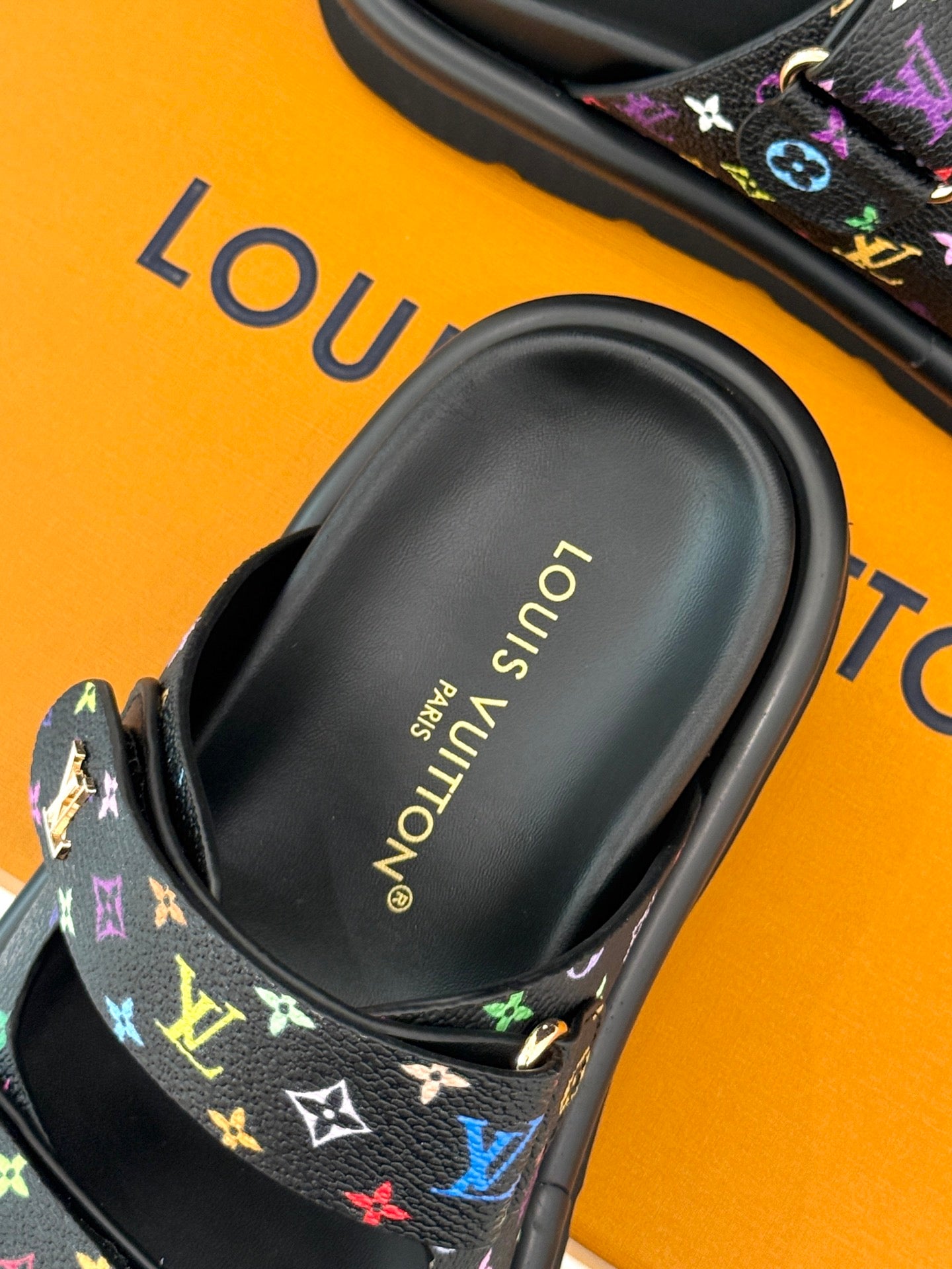 Close-up of Louis Vuitton slide sandal footbed with gold logo text