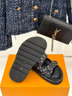 Sole view of black Louis Vuitton slide sandals with multicolor monogram straps