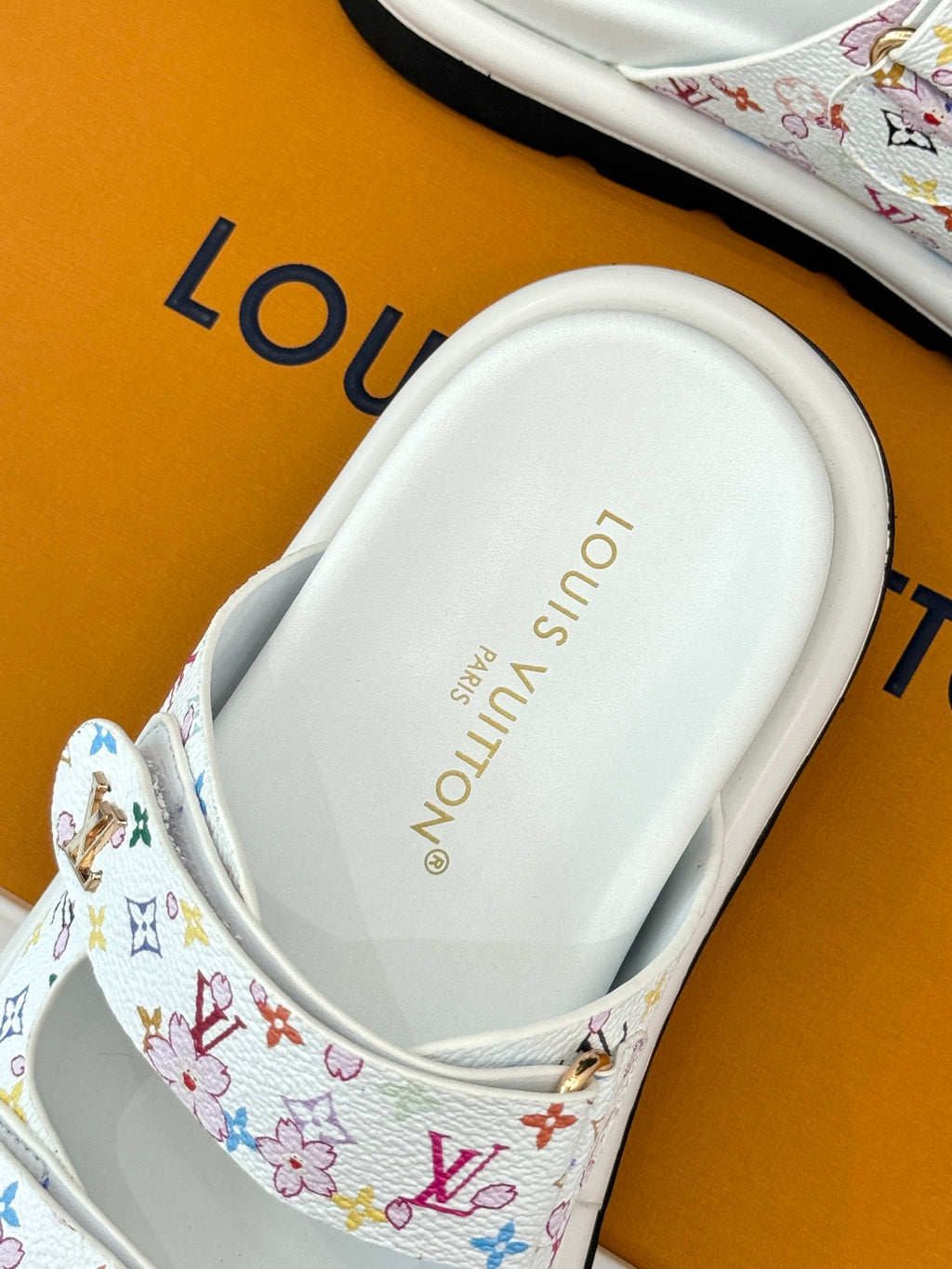 Louis Vuitton ladies luxury shoes, white footbed view with logo text on sandal