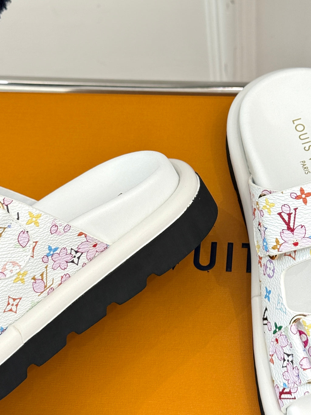 Louis Vuitton ladies luxury shoes, close-up of white slide sandal with multicolor print strap