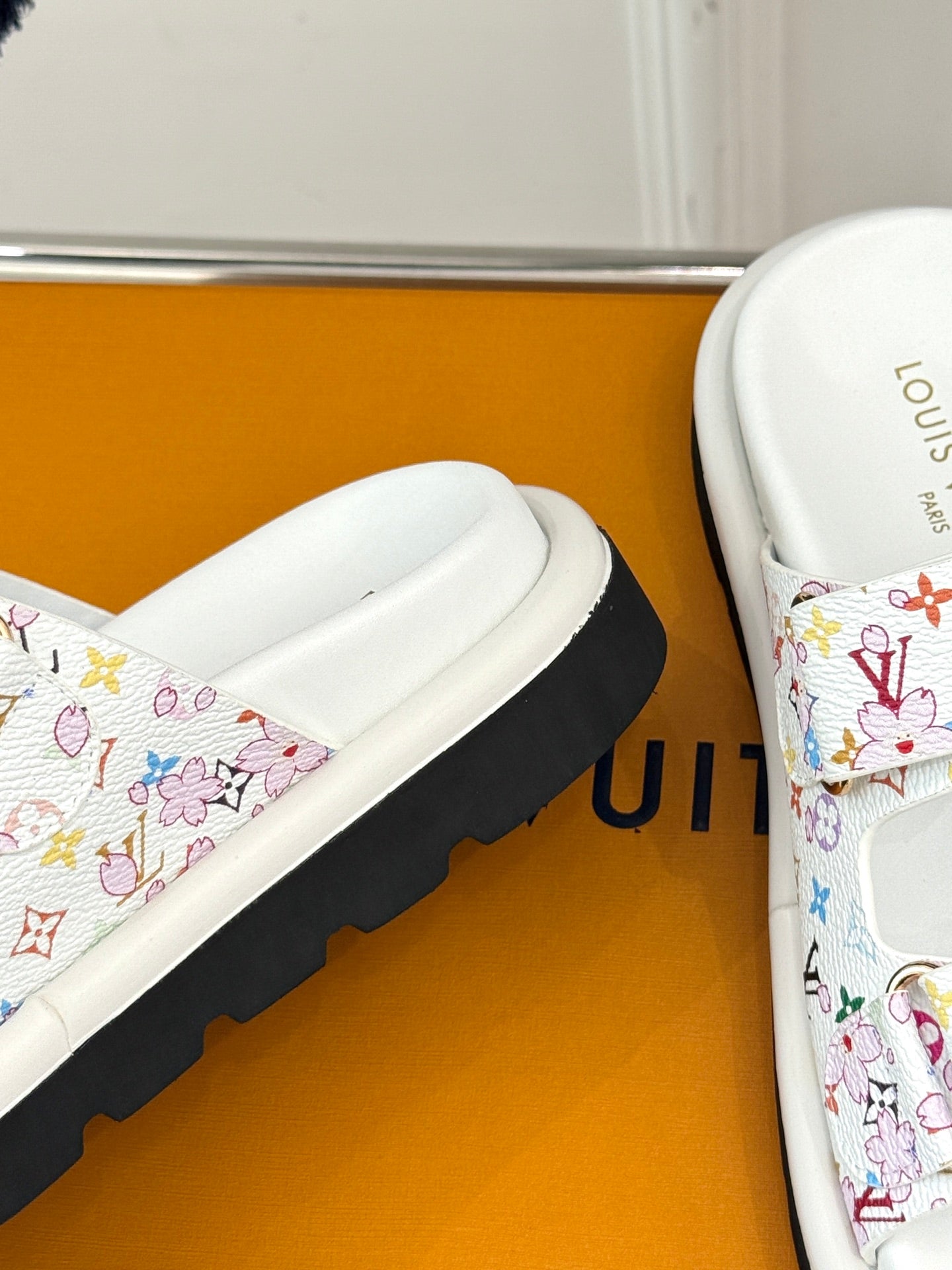Louis Vuitton ladies luxury shoes, close-up of white slide sandal with multicolor print strap