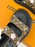 Ladies slide sandals close-up: brown monogram floral strap with black rubber sole