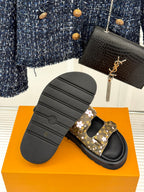 Ladies slide sandals rear view with dark monogram floral strap on black outsole