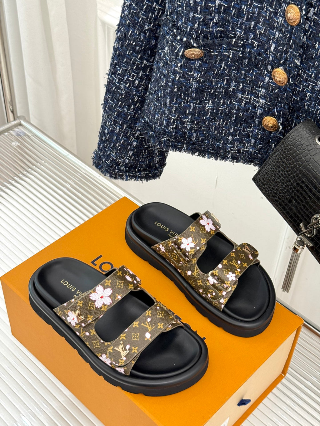 Ladies slide sandals with brown monogram floral straps and black rubber platform soles
