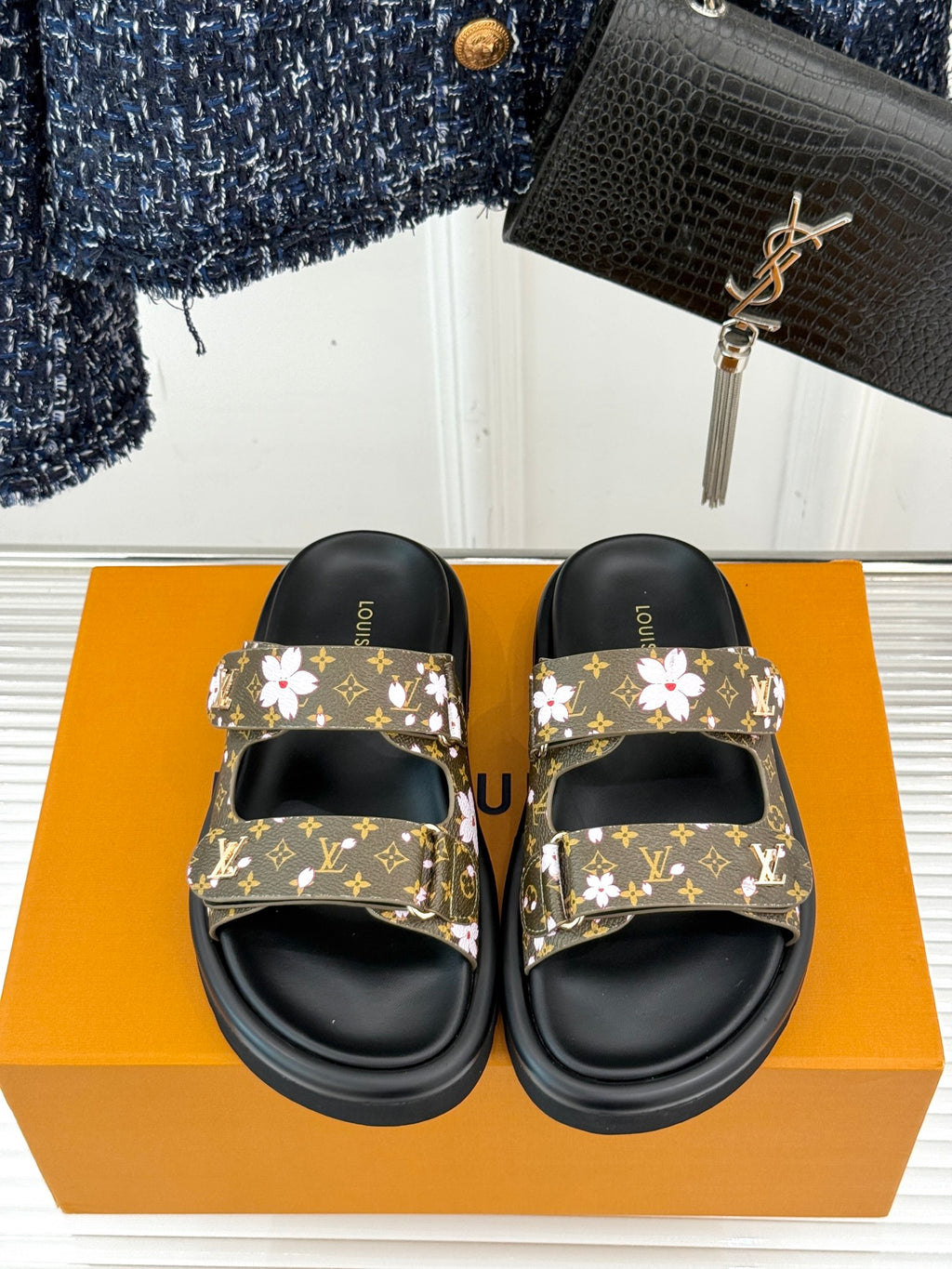 Ladies slide sandals with floral monogram strap tops and black adjustable footbeds