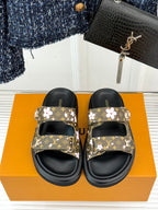 Ladies slide sandals with floral monogram strap tops and black adjustable footbeds