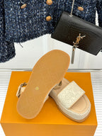 Beige espadrille sandals with white monogram straps and visible sole tread