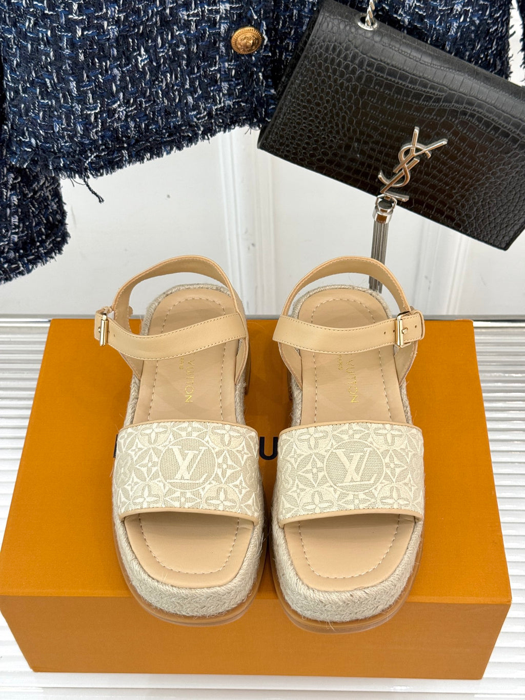 Pair of beige espadrille sandals with white monogram side panels and ankle buckles