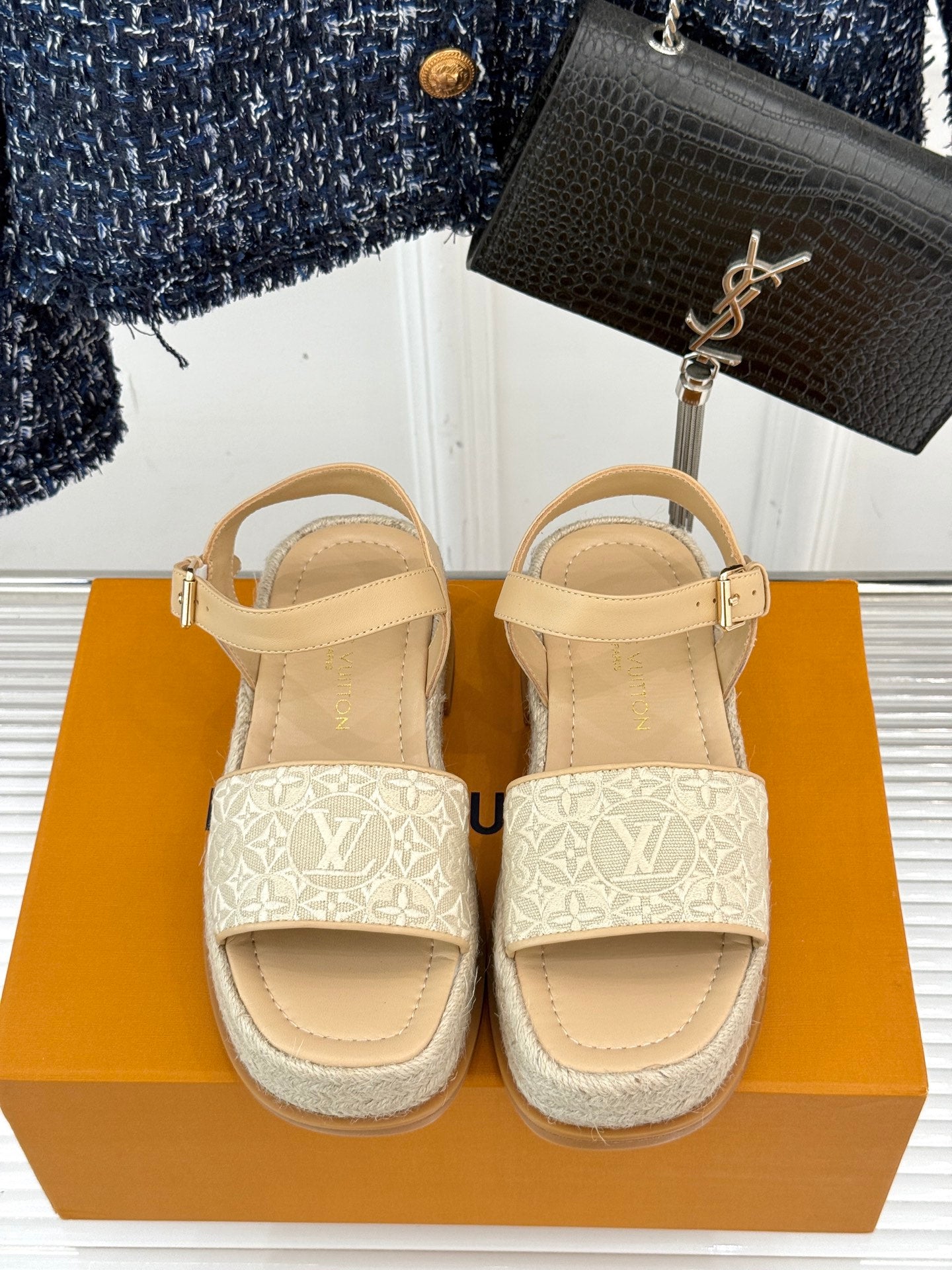 Pair of beige espadrille sandals with white monogram side panels and ankle buckles
