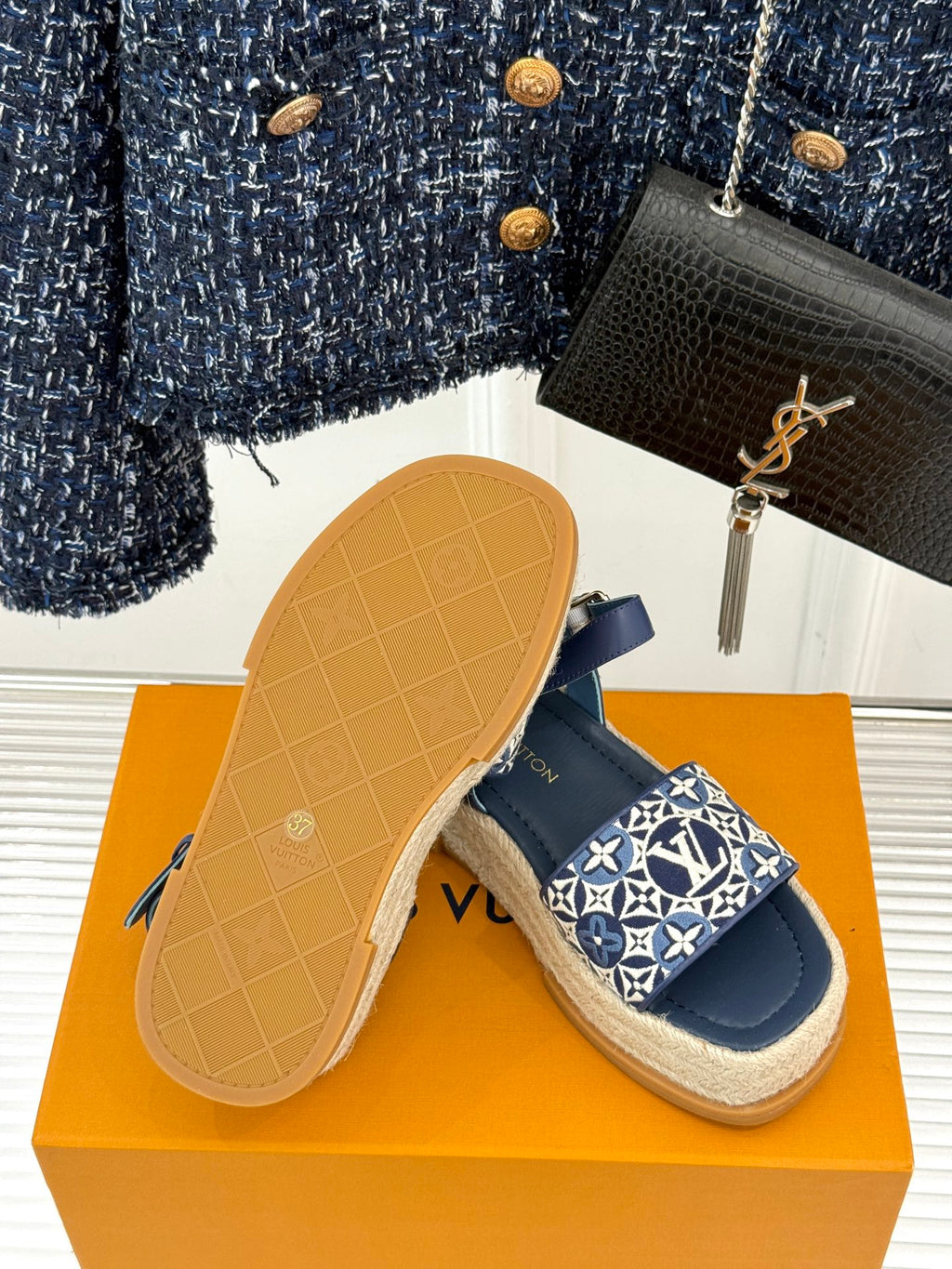 Blue espadrille sandals with monogram strap and visible tan rubber outsole underside