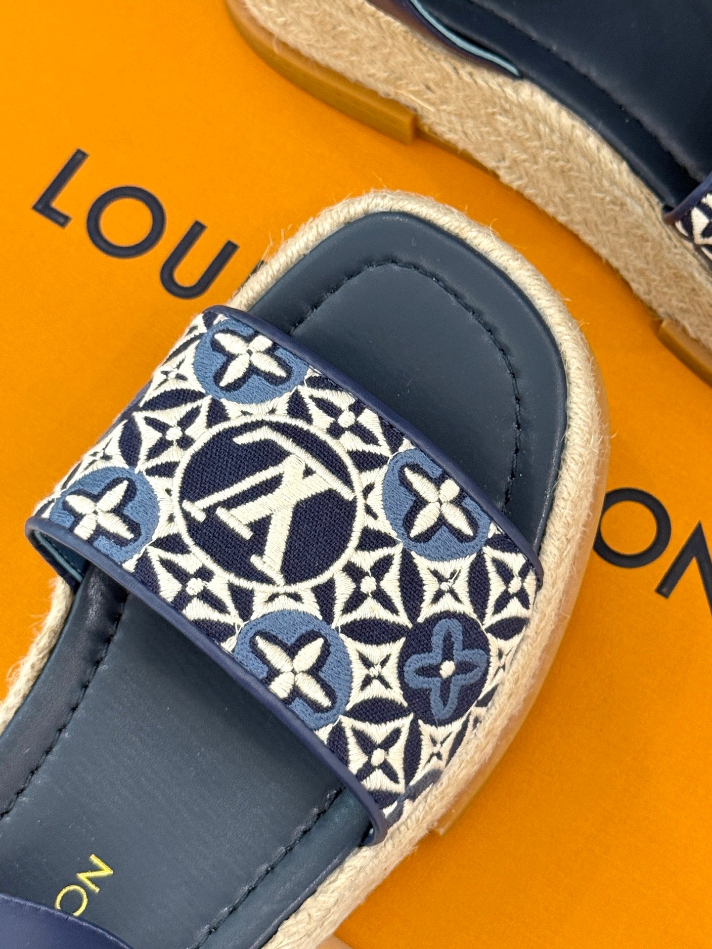 Blue slide espadrille sandal with monogram patterned toe strap and navy leather upper
