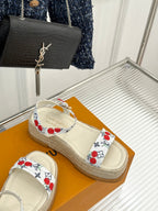 Espadrille slide sandals with white cherry-pattern straps and braided jute sole.