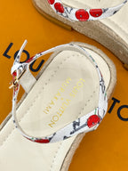 Espadrille sandal insole close-up with gold logo on tan lining.