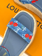 Close-up of blue espadrille sandal with cherry-print fabric strap and stitched edge