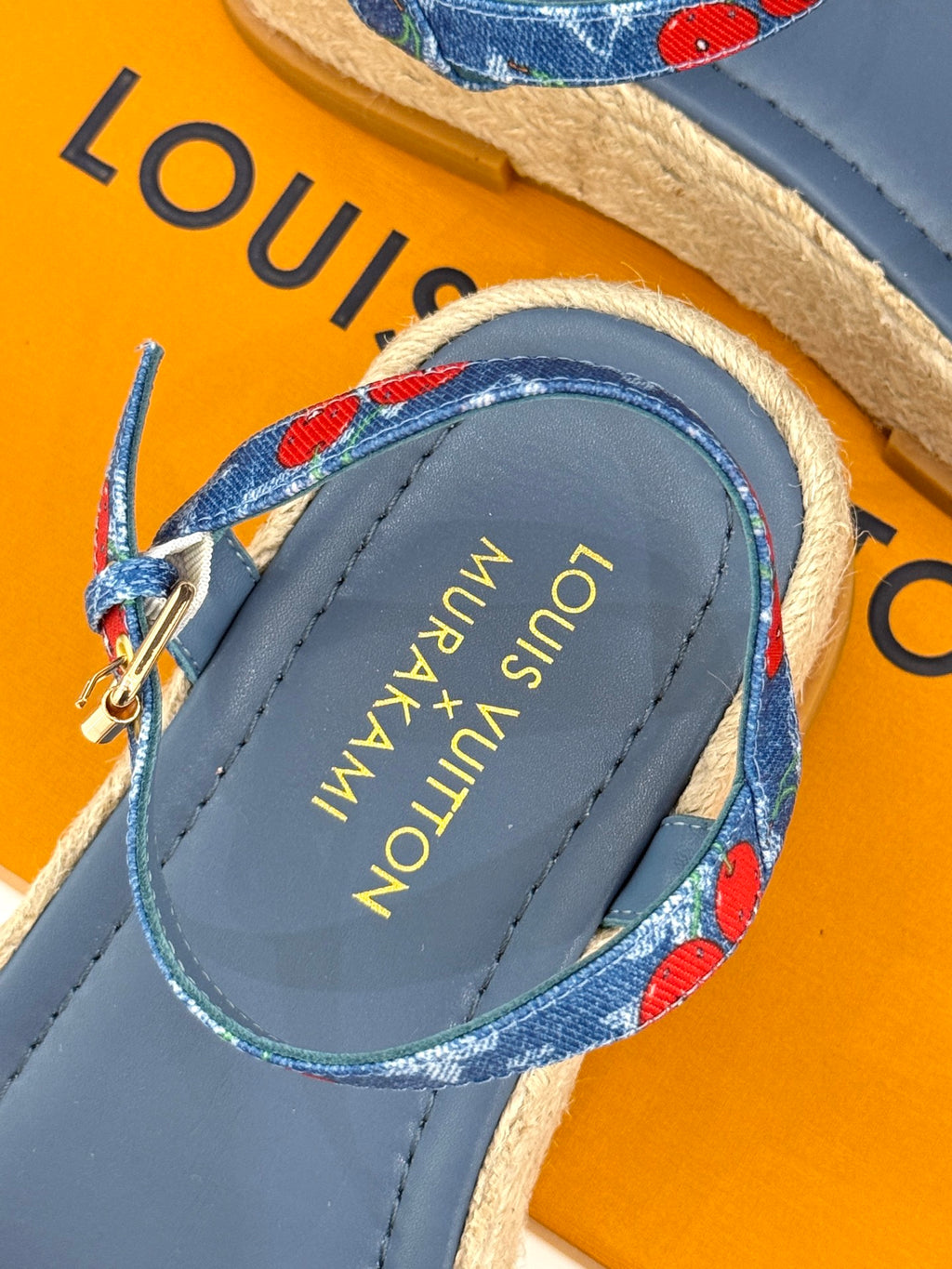 Close-up of blue espadrille slide sandals with brand text on insole