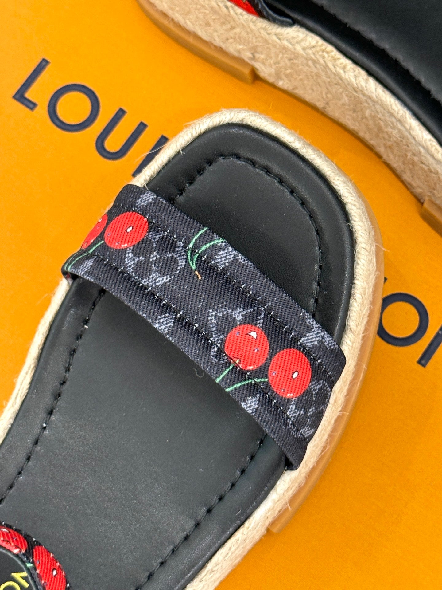 Louis Vuitton black espadrille slide with cherry-pattern strap trim and stitched leather upper.