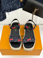 Louis Vuitton black espadrille platform sandals with cherry-pattern straps and gold-tone buckles.