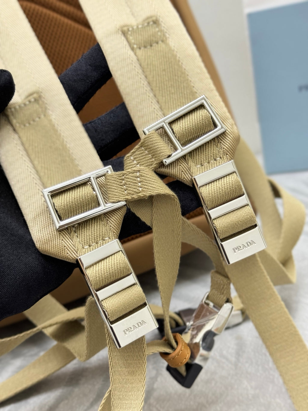 Prada tan backpack close-up of adjustable strap hardware with silver buckles