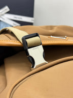 Prada tan backpack close-up of strap buckle and silver hardware with logo detail