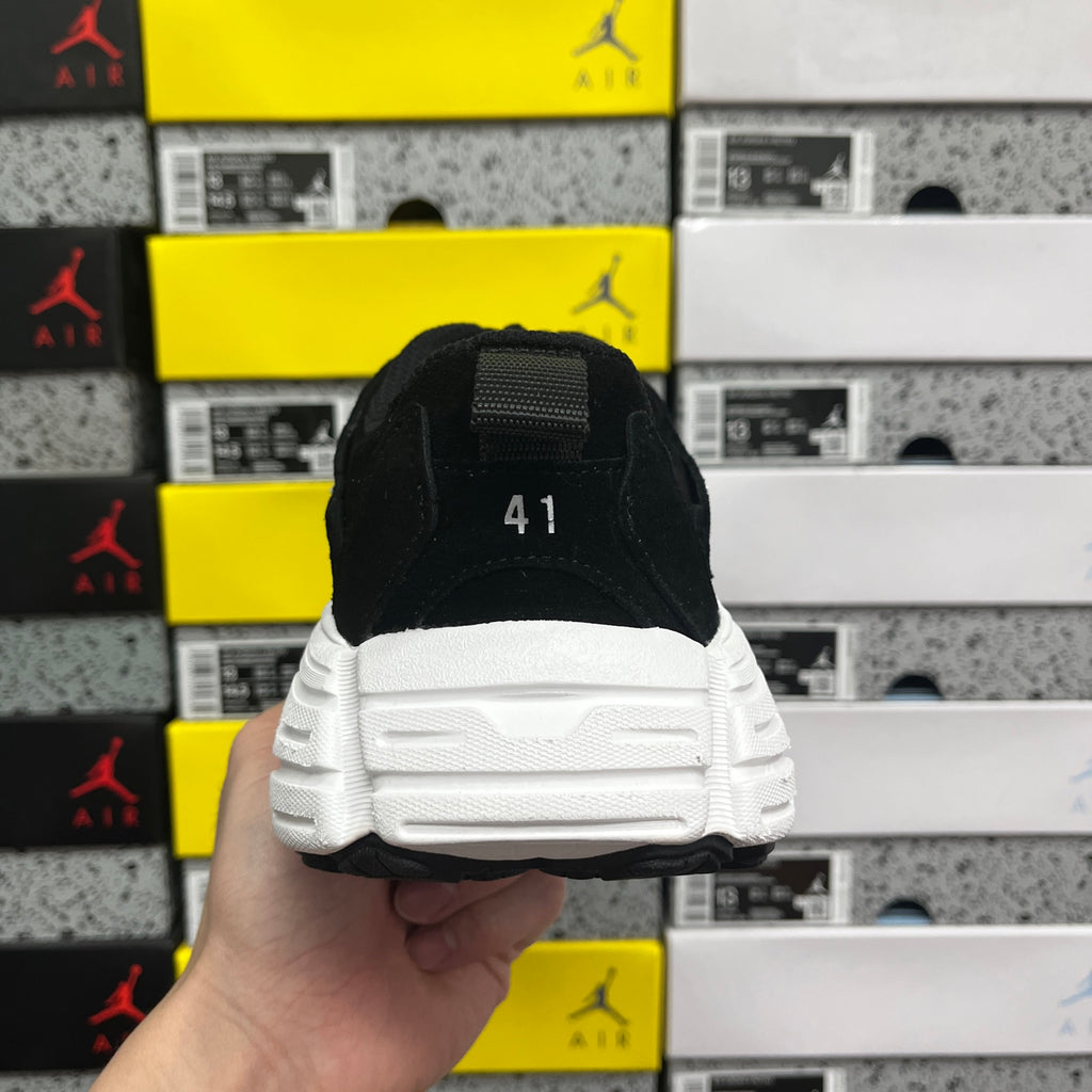 Black sneaker heel with treaded white sole, back tab detail