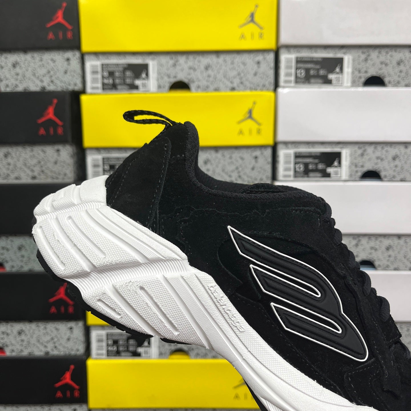 Black suede lace-up sneaker with white ridged sole and side logo