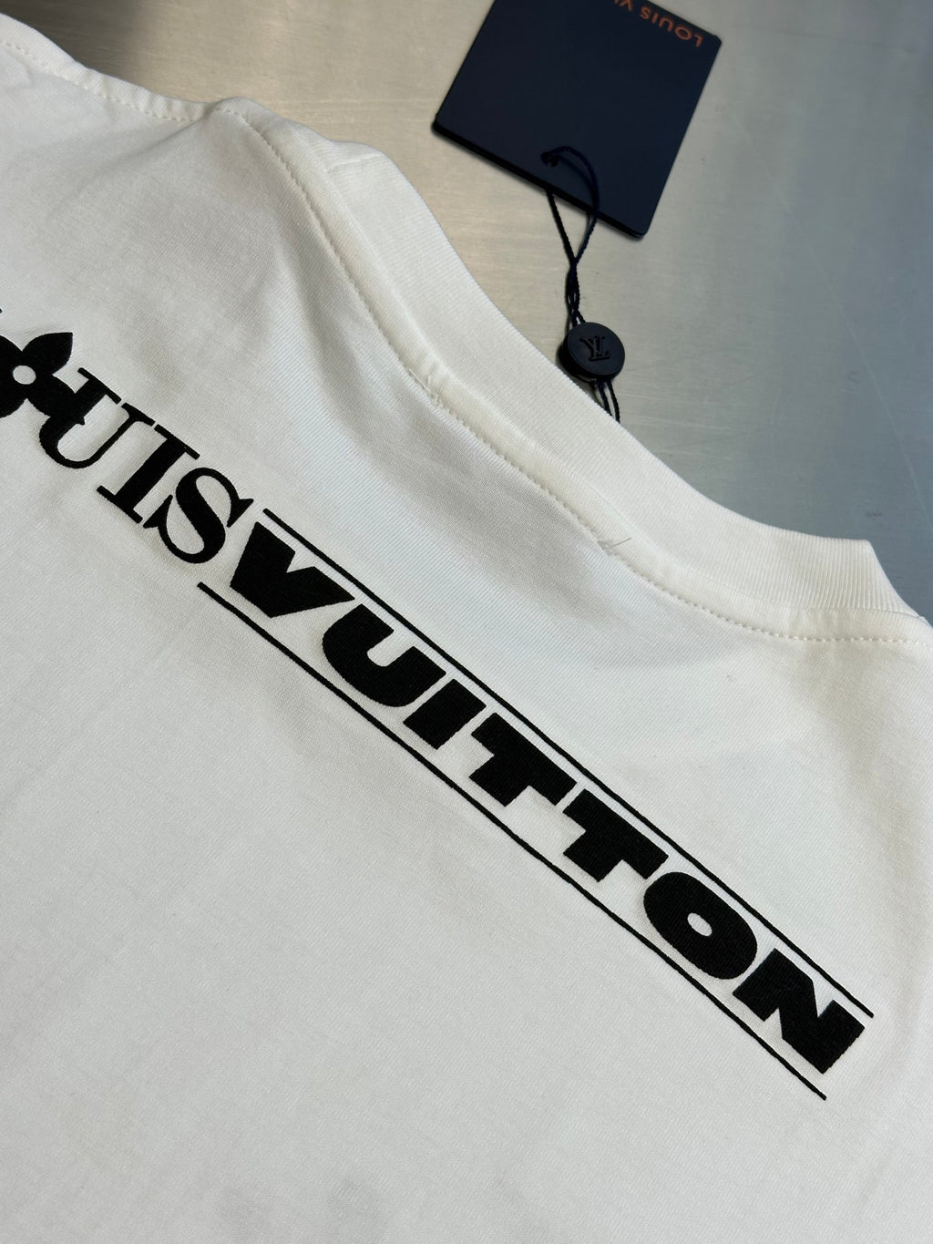 White Louis Vuitton T-shirt with large black “Louis Vuitton” chest logo