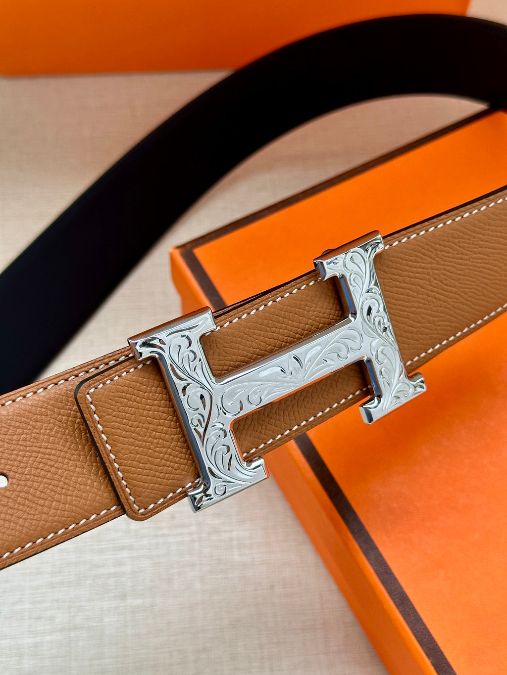 Leather belt with silver H buckle on tan-brown strap