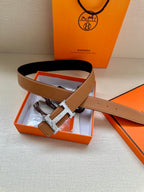Tan-brown leather belt with silver H buckle, shown with gift box