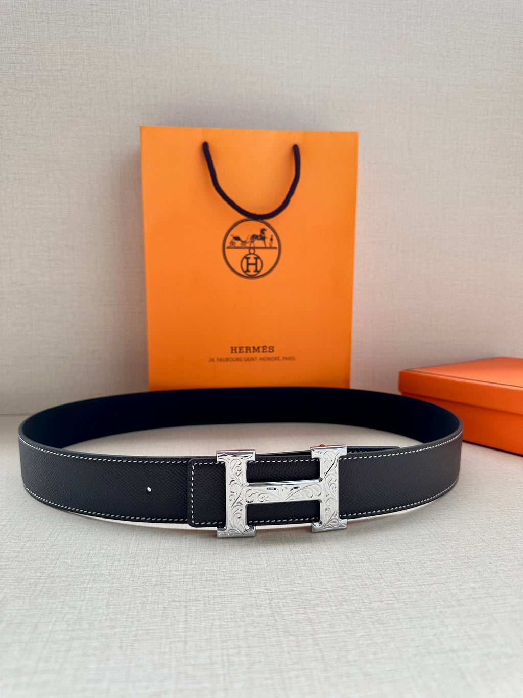 Hermes belt in black leather with silver square H buckle and stitched holes.