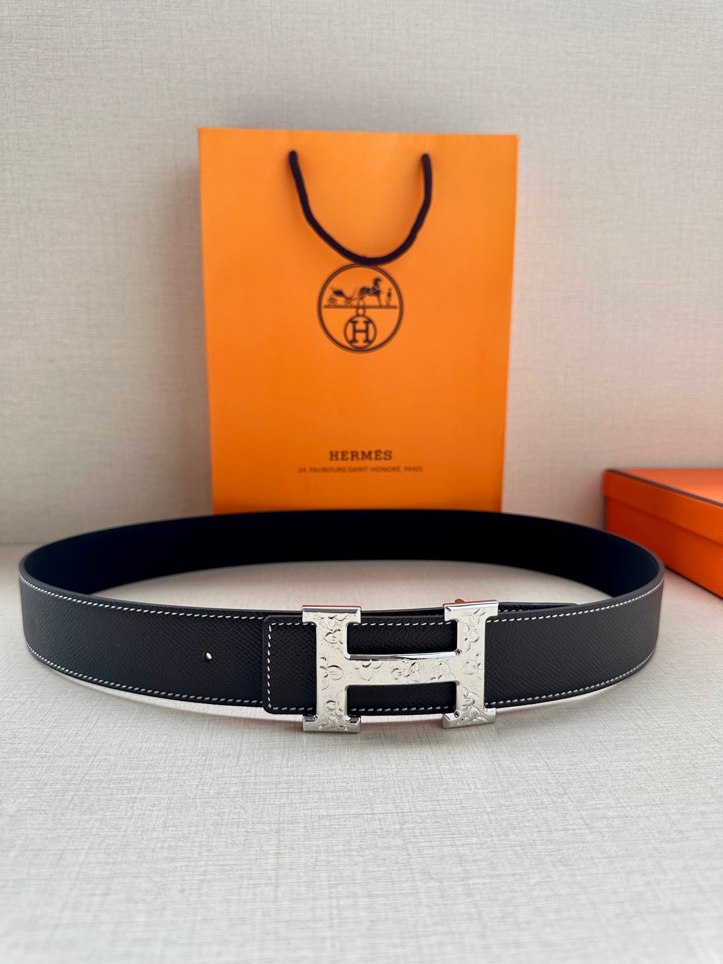 Dark navy leather belt with silver-tone buckle and stitched edges.