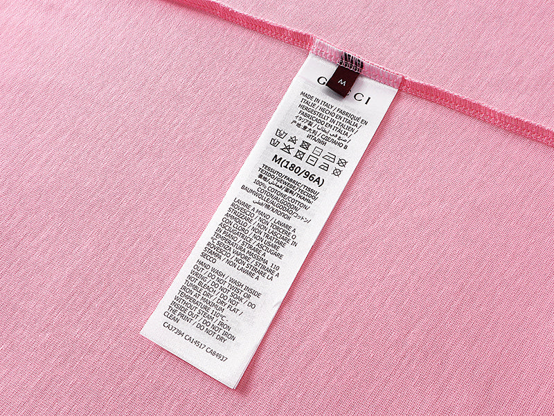 Pink short-sleeve T-shirt care label tag on the inner neck seam