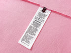 Pink short-sleeve T-shirt care label tag on the inner neck seam