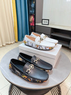 Luxury loafers with gold logo buckles, white and dark pairs on display