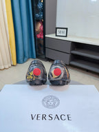 Dark luxury loafers from behind with red logo circles on heels