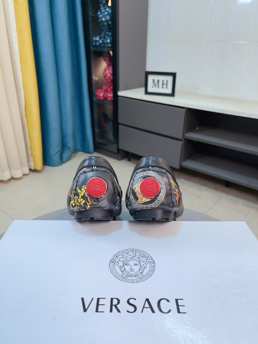 Dark luxury loafers from behind with red logo circles on heels
