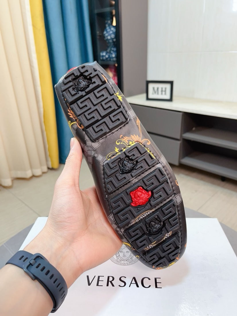 Luxury loafer sole with dark geometric pattern and red emblem, held in hand