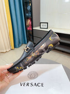 Dark luxury loafer showing tread sole, gold-tone buckle, patterned upper