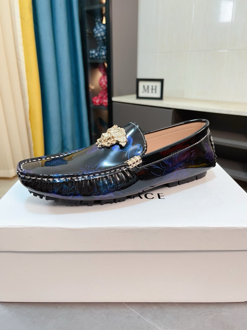 Dark blue patterned loafers with gold emblem on the vamp and stitched sole edge