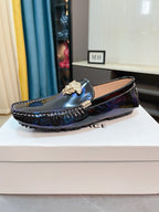 Dark blue patterned loafers with gold emblem on the vamp and stitched sole edge