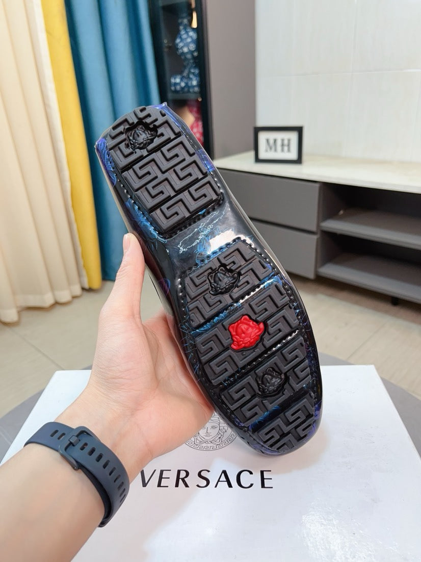 Black-and-blue patterned slip-on loafers with Greek key design and red emblem