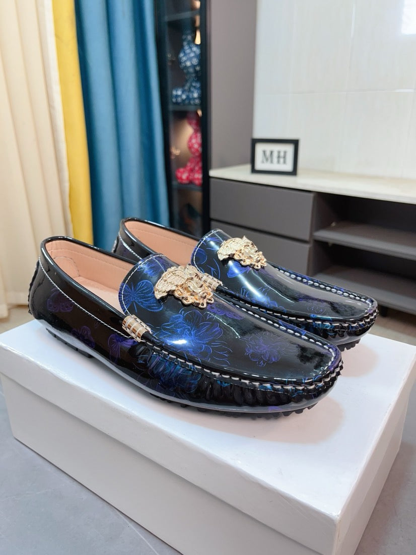 Pair of dark blue patterned loafers with gold lion clasp and decorative buckle