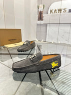 Dark gray suede loafers with yellow horse emblem and metal buckle detail