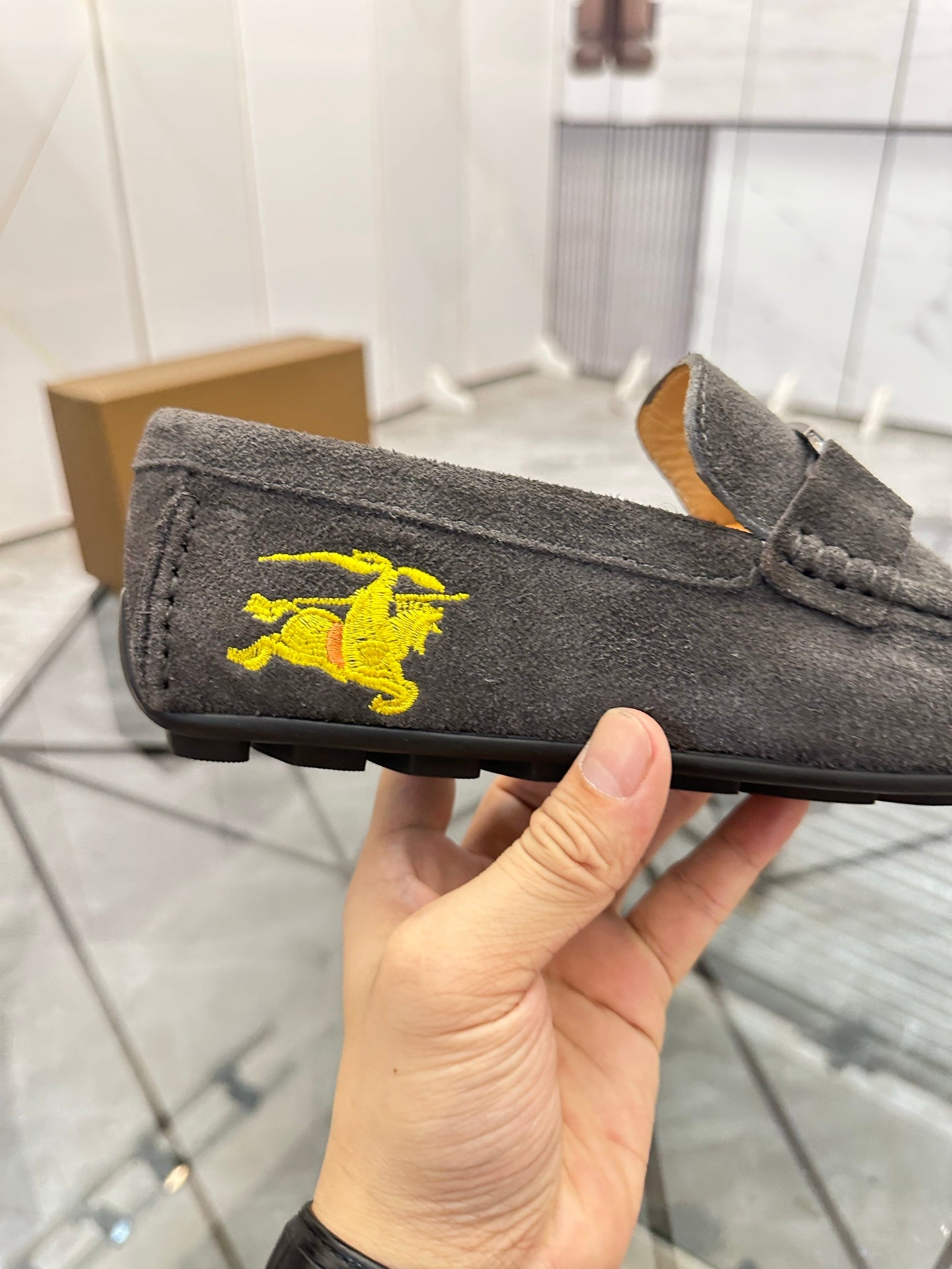 Dark gray suede loafer with yellow horse emblem on side panel
