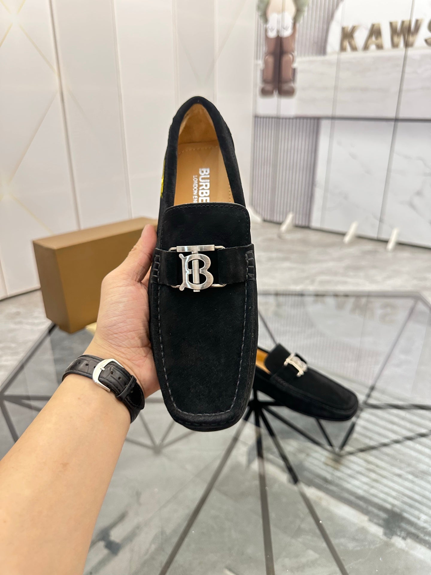 Burberry black loafer with gold-tone “B” buckle and yellow interior lining