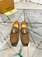 Pair of brown suede loafers with B logo hardware on the front, slip-on style.