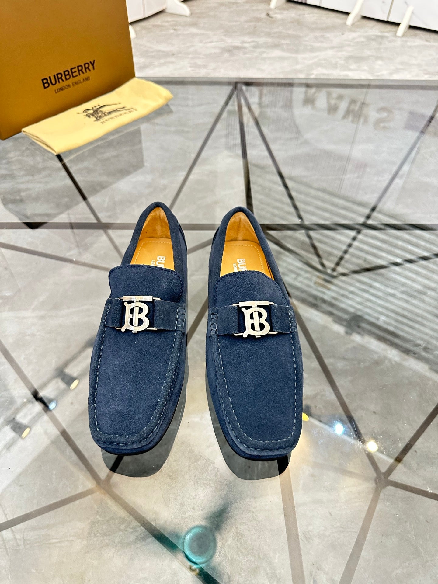 Pair of navy suede loafers with gold-tone B logo on front