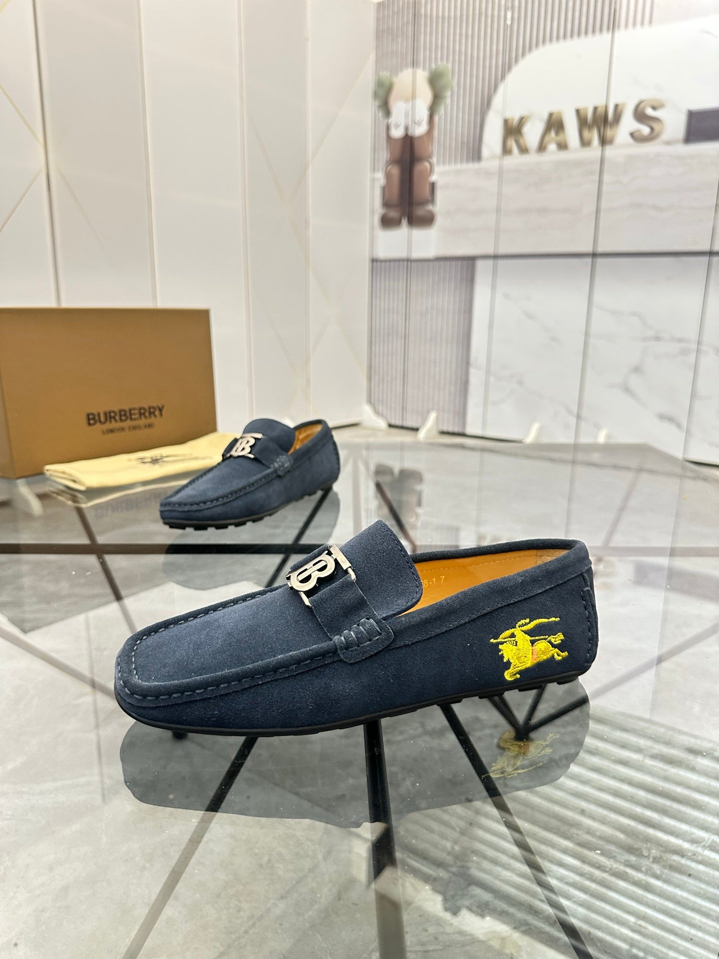 Navy suede loafer with gold-tone B buckle and yellow horse logo on side