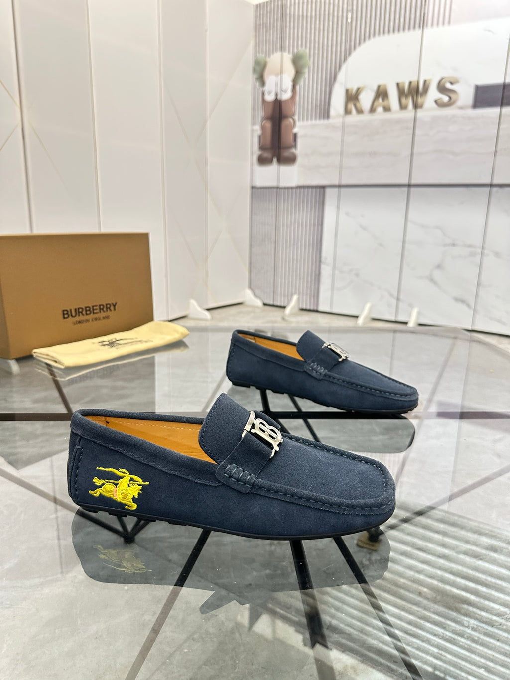 Navy suede loafer with yellow horse emblem and gold-tone B buckle