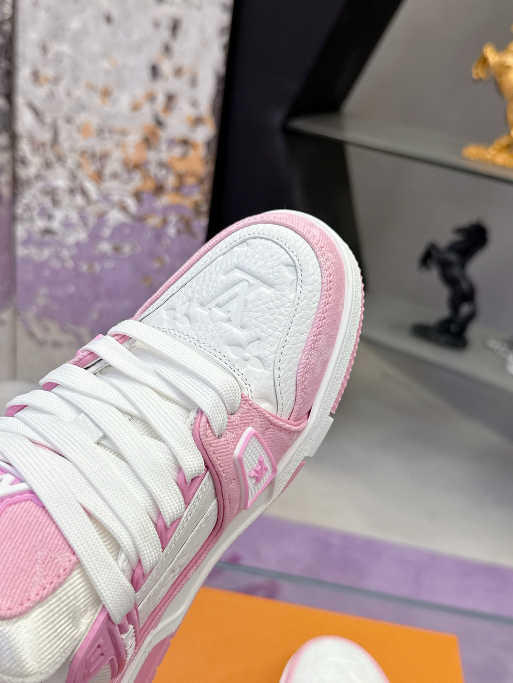Pink and white Louis Vuitton sneaker close-up on side, textured leather